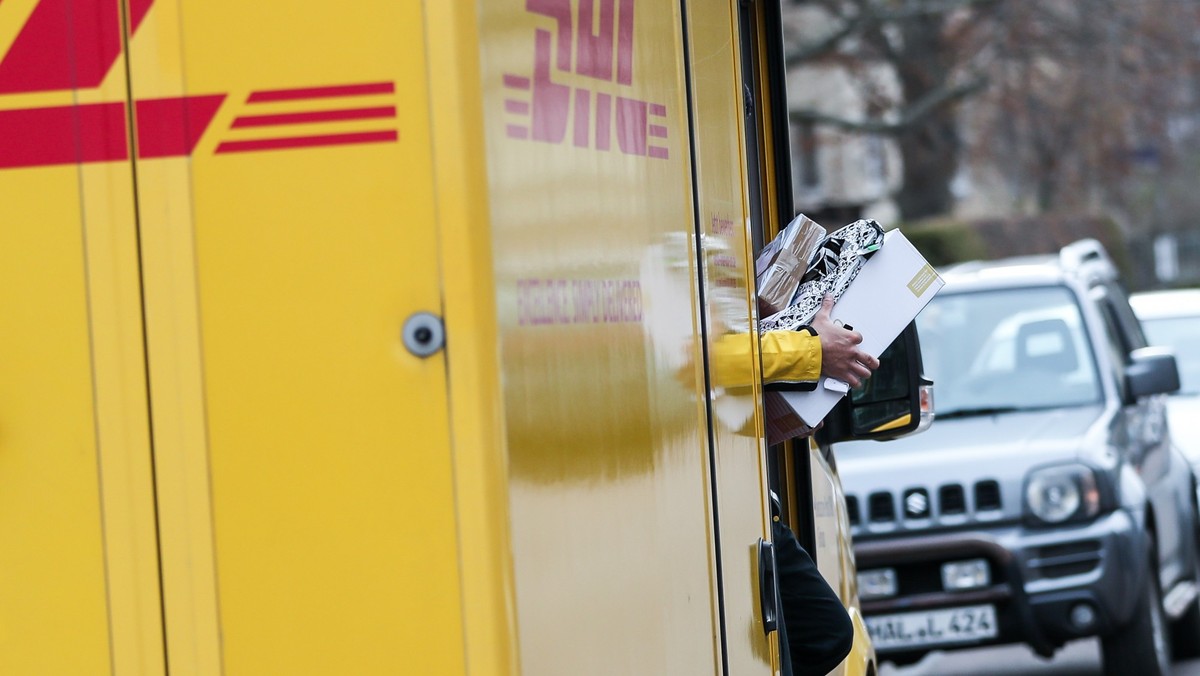 ARCHIV - 11.12.2019, Sachsen-Anhalt, Halle: Ein DHL Paketzusteller verlässt mit mehreren Sendungen sein Fahrzeug im Paulusviertel. Immer mehr Bürger machen ihrem Ärger über die Deutsche Post Luft. (zu ...