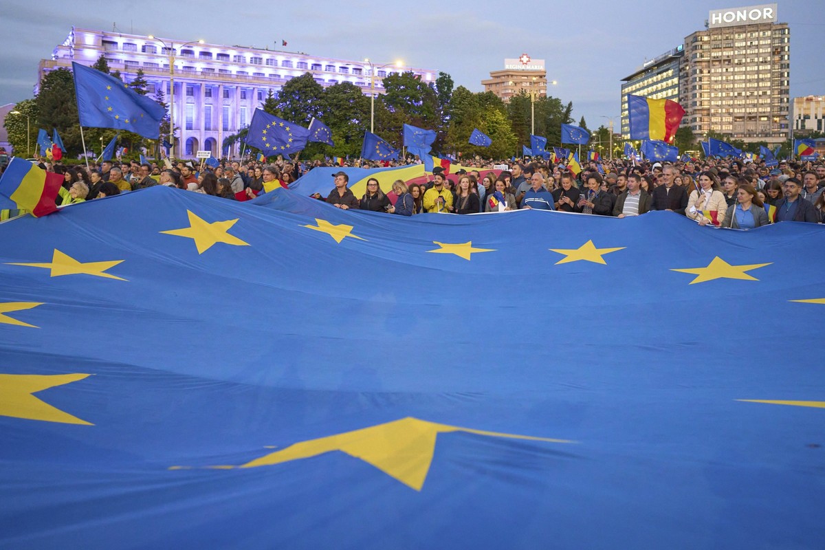 09.05.2025, Rumänien, Bukarest: Menschen halten eine Flagge der Europäischen Union während einer Pro-EU-Kundgebung vor der zweiten Runde der Präsidentschaftswahlen. Foto: Vadim Ghirda/AP/dpa +++ dpa-B ...