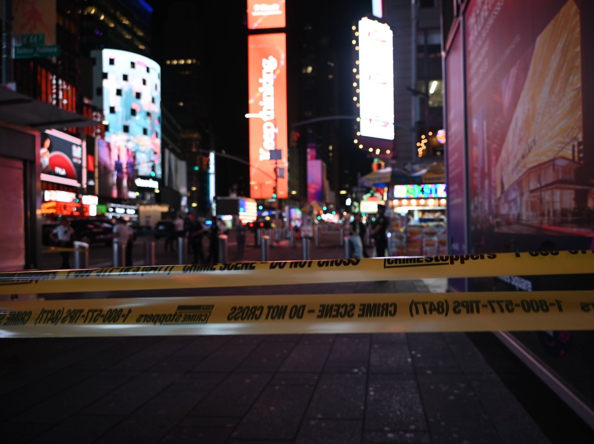 Three People Shot At West 44th Street And 7th Avenue In Times Square Officers of the New York City Police Department guard the shooting scene with police tape and block off access to pedestrian and ve ...