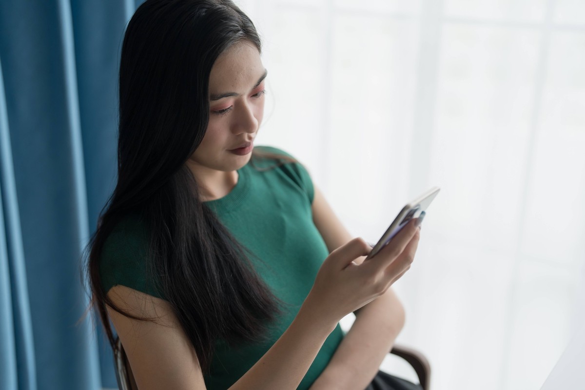 Asiatische Frau nutzt Smartphone College Handy süchtig verbringen Zeit überprüfen Nachrichten Technologie E-Commerce-Konzept Asiatische Frau nutzt Smartphone College Handy süchtig verbringen Zeit über ...