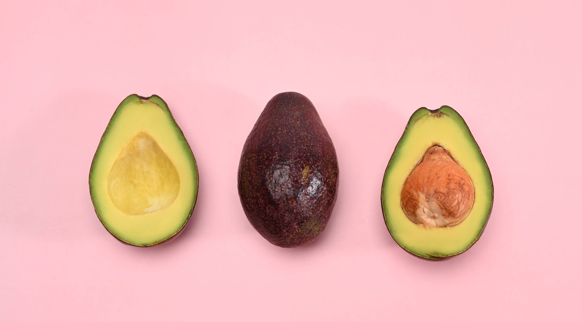 Whole and half avocado isolated on pink background. Whole and half avocado isolated on pink background. Copyright: x RECORD DATE NOT STATED