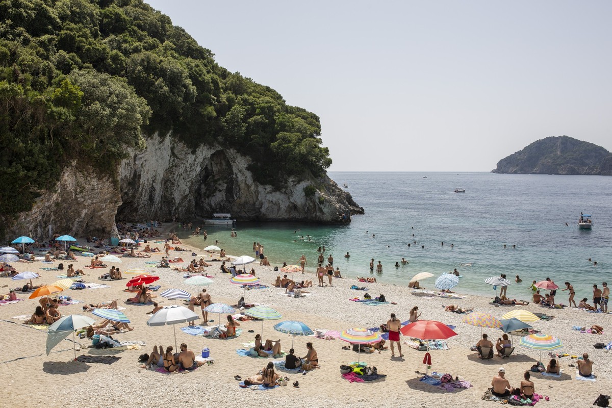 14.07.2023, Griechenland, Paleokastritsa: Menschen halten sich an diesem heißen Tag zur Abkühlung am Rovinia-Strand bei Paleokastritsa auf der Insel Korfu auf. Hitze ohne Ende in weiten Teilen Grieche ...