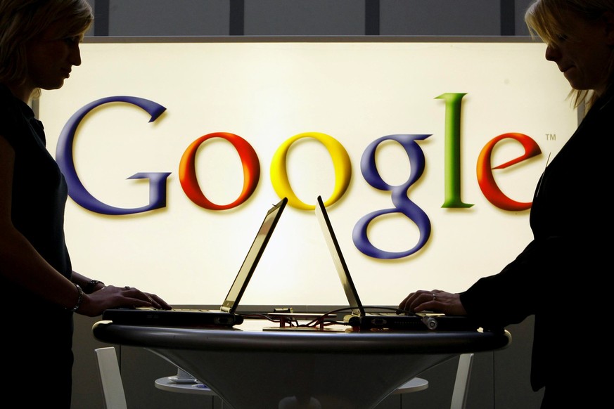 FILE - In this April 17, 2007 file photo, exhibitors work on laptop computers in front of an illuminated sign of the Google logo at the industrial fair Hannover Messe in Hanover, Germany. The European ...