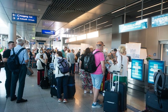Passengers are seen waiting in a long line in front of Eurowing ticket service counter at Duesseldorf airport in Duesseldorf, Germany on June 30, 2022 as governments plans to rescue chaos to bring mor ...
