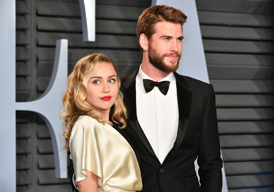 BEVERLY HILLS, CA - MARCH 04: Miley Cyrus (L) and Liam Hemsworth attend the 2018 Vanity Fair Oscar Party hosted by Radhika Jones at Wallis Annenberg Center for the Performing Arts on March 4, 2018 in  ...