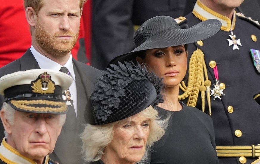 Britain's King Charles III, from bottom left, Camilla, the Queen Consort, Prince Harry and Meghan, Duchess of Sussex watch as the coffin of Queen Elizabeth II is placed into the hearse following the s ...