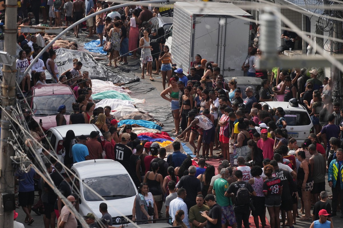Residents look at the bodies of people killed the day before during a police raid targeting the Comando Vermelho gang in the Complexo da Penha favela of Rio de Janeiro, Brazil, Wednesday, Oct. 29, 202 ...