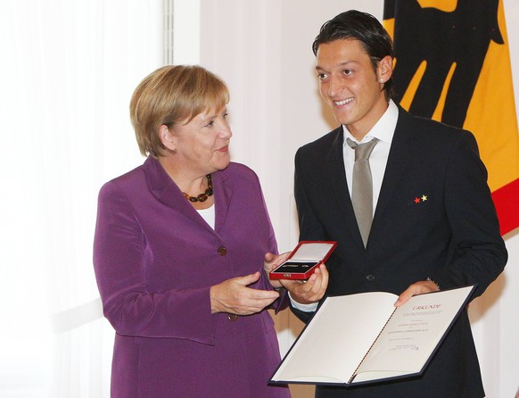 Merkel verleiht Özil und der Nationalmannschaft 2010 das Silberne Lorbeerblatt.