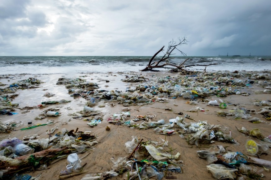 Garbage on beach, environmental pollution in Bali Indonesia. Drops of water are on camera lens. Dramatic view