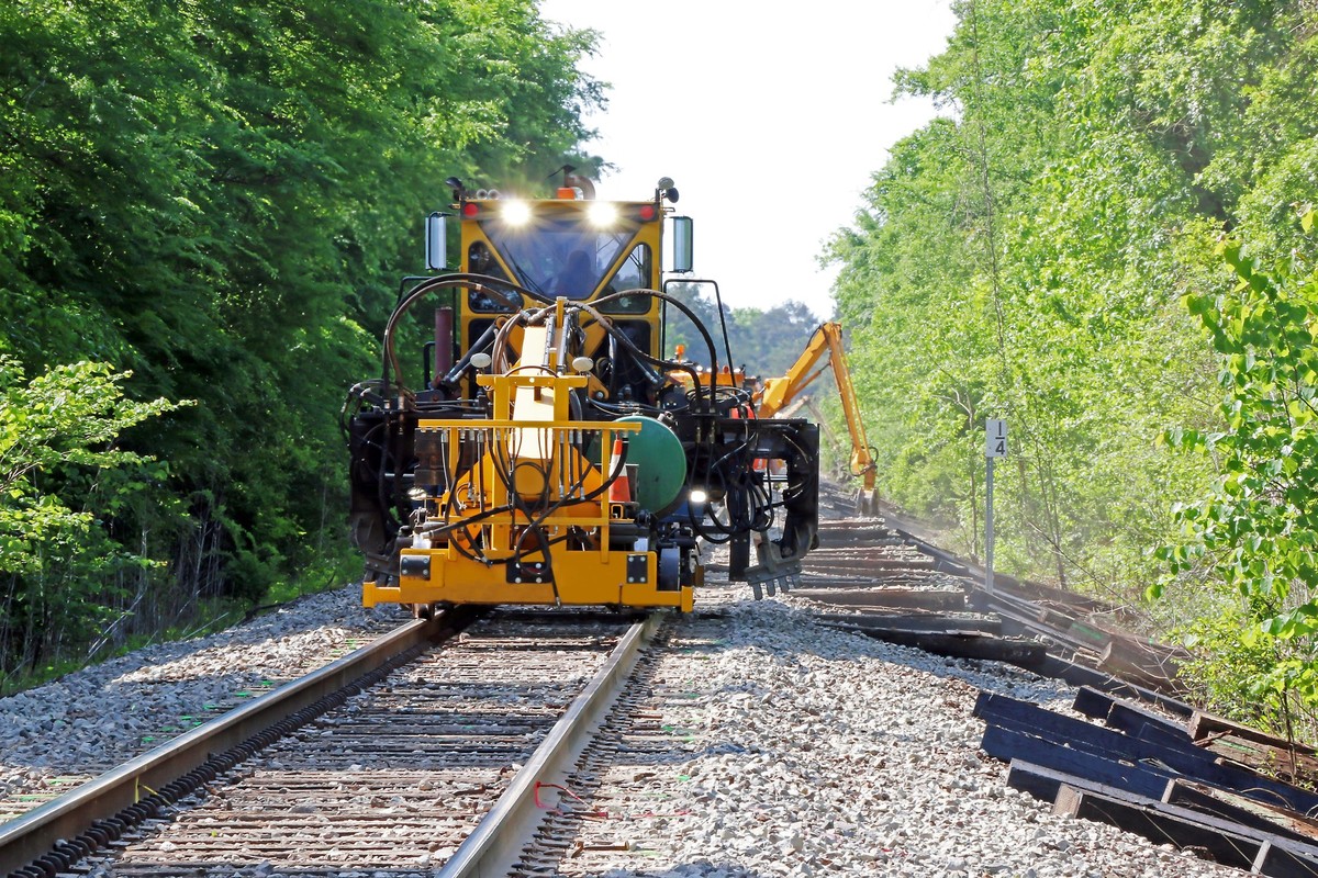 Railroad repair company removing railroad ties and install new ones, ties get weak from heavy use.