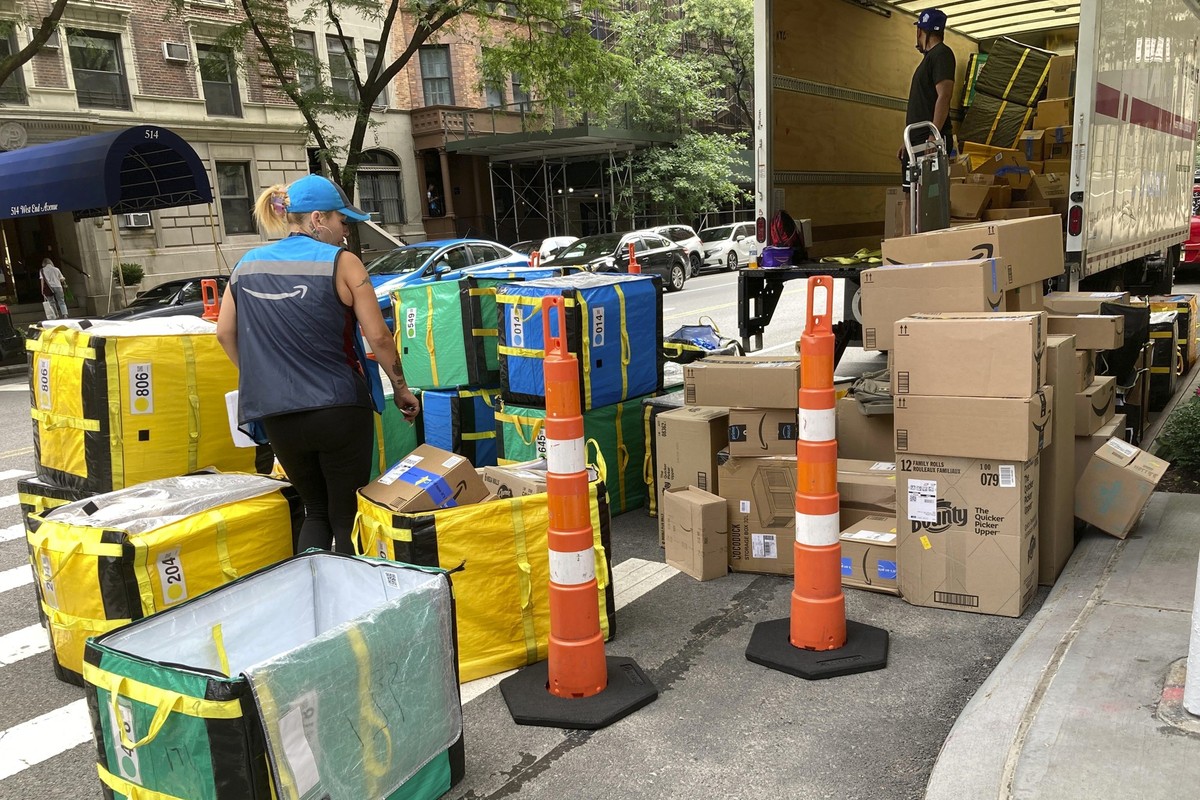 FILE - An Amazon worker sorts deliveries on a street corner on New York&#039;s Upper West Side, Aug. 14, 2023. (AP Photo/Richard Drew, File)