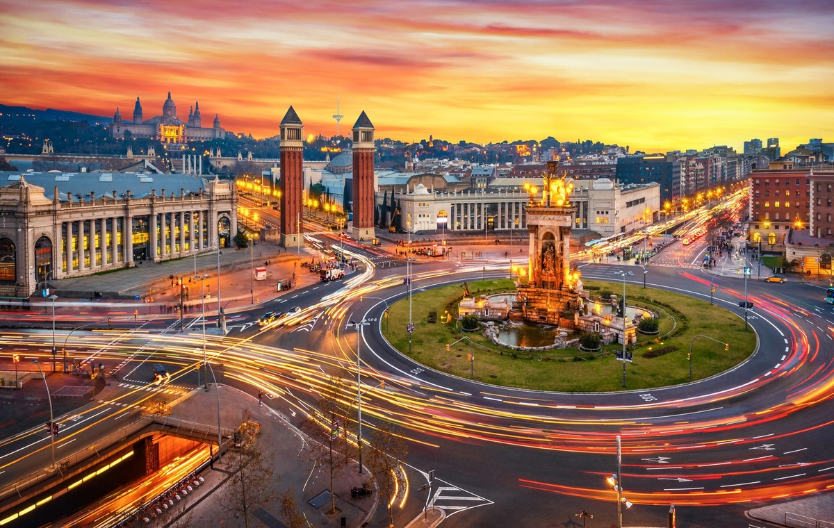 Long exposure photo of Fira de Barcelona, Plaça d&#039;espanya (Spain square) and montjuic mountain in Barcelona at sunset with car light trails . Spain