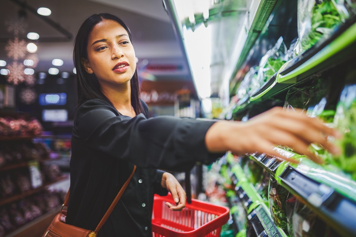 Shot of a young woman shopping for fresh vegetables in a grocery store