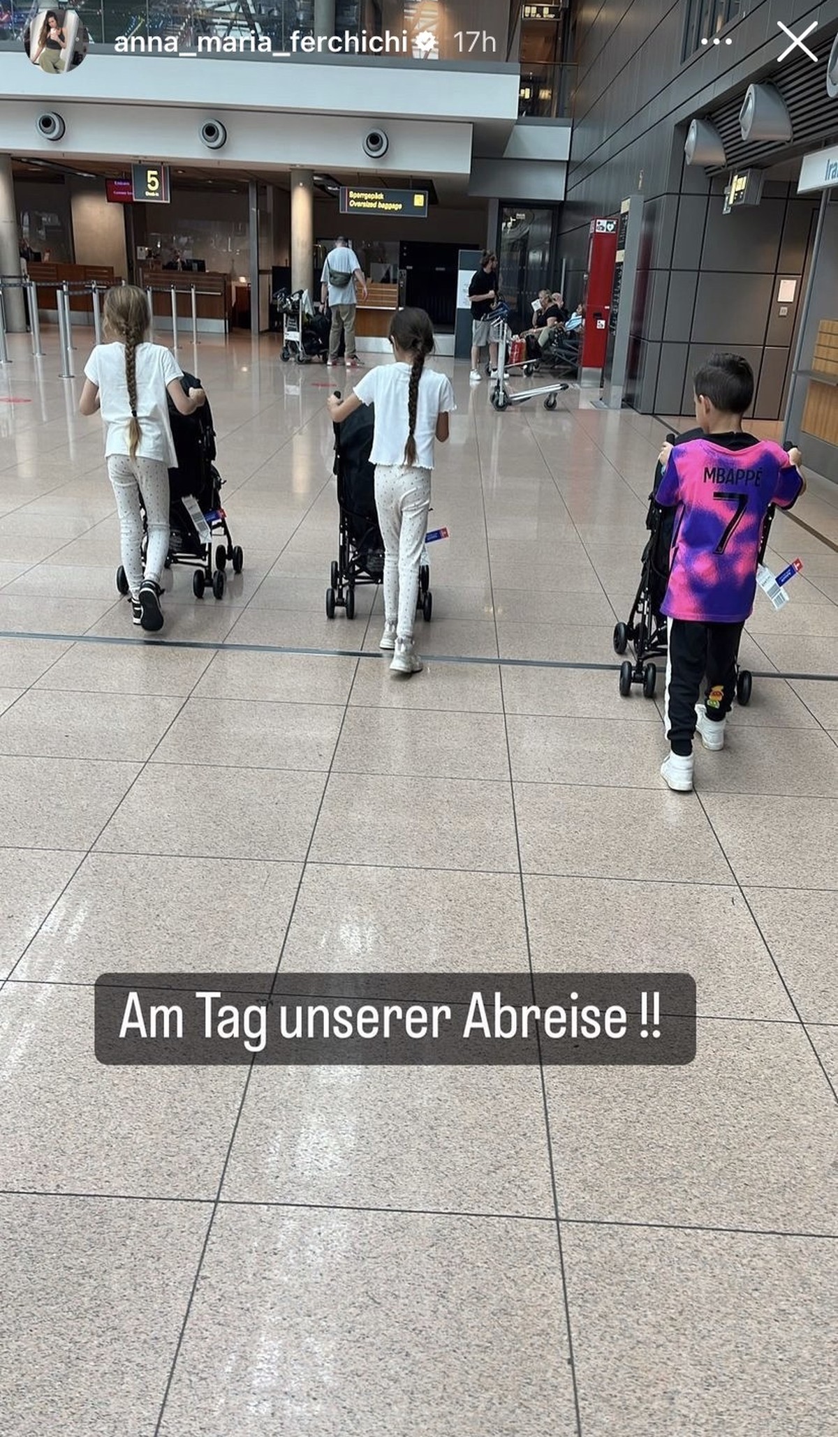 Hier sind drei ihrer größeren Kinder zu sehen, die die Drillinge im jeweiligen Kinderwagen schieben.