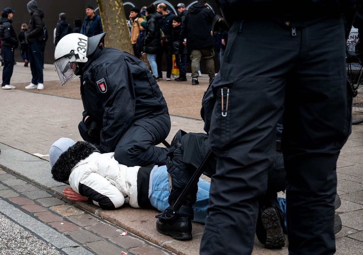 04.03.2023, Hamburg: Ein Polizist hält in der Einkaufsstraße Mönkebergstraße einen Jugendlichen fest. In der Hamburger Innenstadt ist es am Nachmittag zu einer Auseinandersetzung zwischen Dutzenden Ju ...