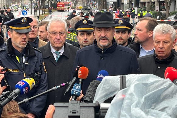 13.02.2025, Bayern, München: Bayerns Ministerpräsident Markus Söder (CSU, M), Innenminister Joachim Herrmann (CSU, 2.v.l.) und Dieter Reiter (SPD, r) geben am Einsatzort ein Statement. In der Münchner ...