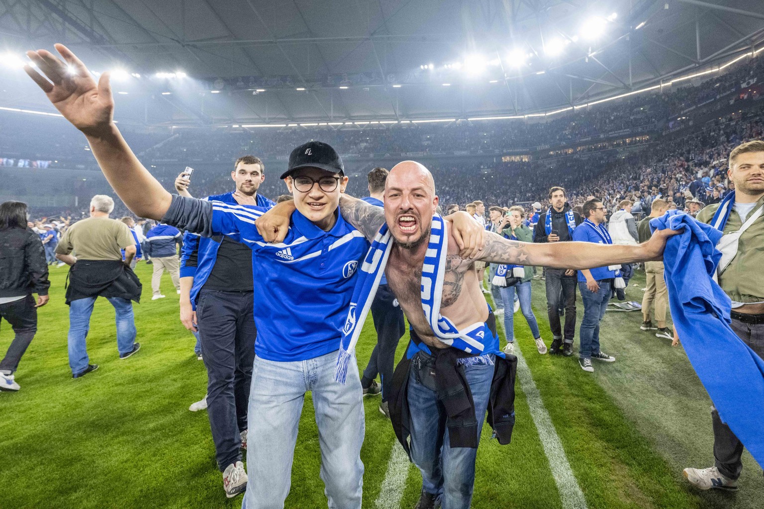 Fußball: 2. Bundesliga, FC Schalke 04 - FC St. Pauli, 33. Spieltag, Veltins Arena: Schalker Fans haben den Rasen gestürmt und bejubeln den Aufstieg.