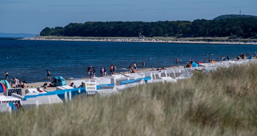 04.09.2023, Mecklenburg-Vorpommern, Zinnowitz: Touristen laufen bei sonnigem Wetter über der Strand. In den kommenden Tagen soll es laut Wetterdienst sonnig werden. Foto: Stefan Sauer/dpa +++ dpa-Bild ...