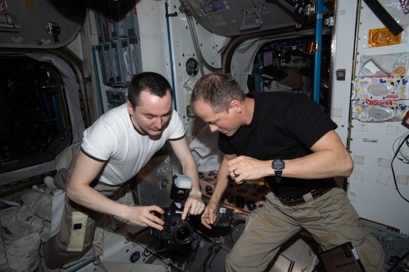 iss066e157130 (March 4, 2022) --- Expedition 66 Flight Engineers (from left) Pyotr Dubrov from Roscosmos and Tom Marshburn of NASA check out photogrpahy gear inside the International Space Station&#03 ...