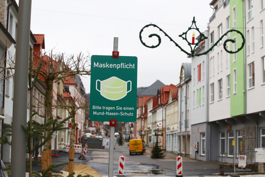 Ein Hinweisschild auf die Maskenpflicht steht in der Fußgängerzone von Heiligenstadt im Eichsfeld-Kreis. Für den Kreis galt bereits seit dem 28.12.2020 eine ganztägige Ausgangssperre und wegen hoher Infektionszahlen noch strengere Kontaktbeschränkungen.