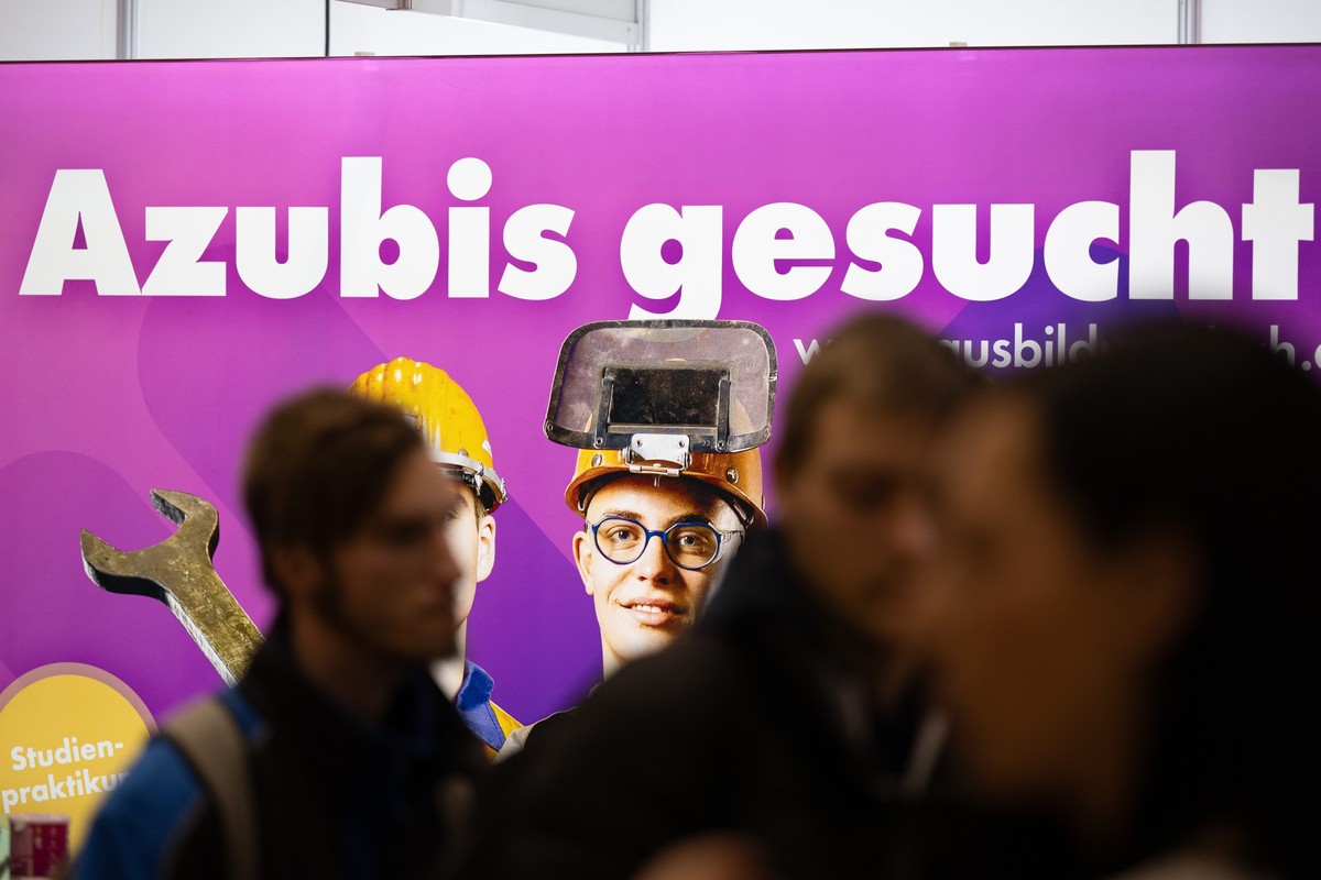 ARCHIV - 19.01.2024, Sachsen, Dresden: Besucher stehen auf einer Jobmesse vor dem Schriftzug «Azubis gesucht». (zu dpa: «Tausende Azubis pendeln für ihre Ausbildung») Foto: Sebastian Kahnert/dpa +++ d ...