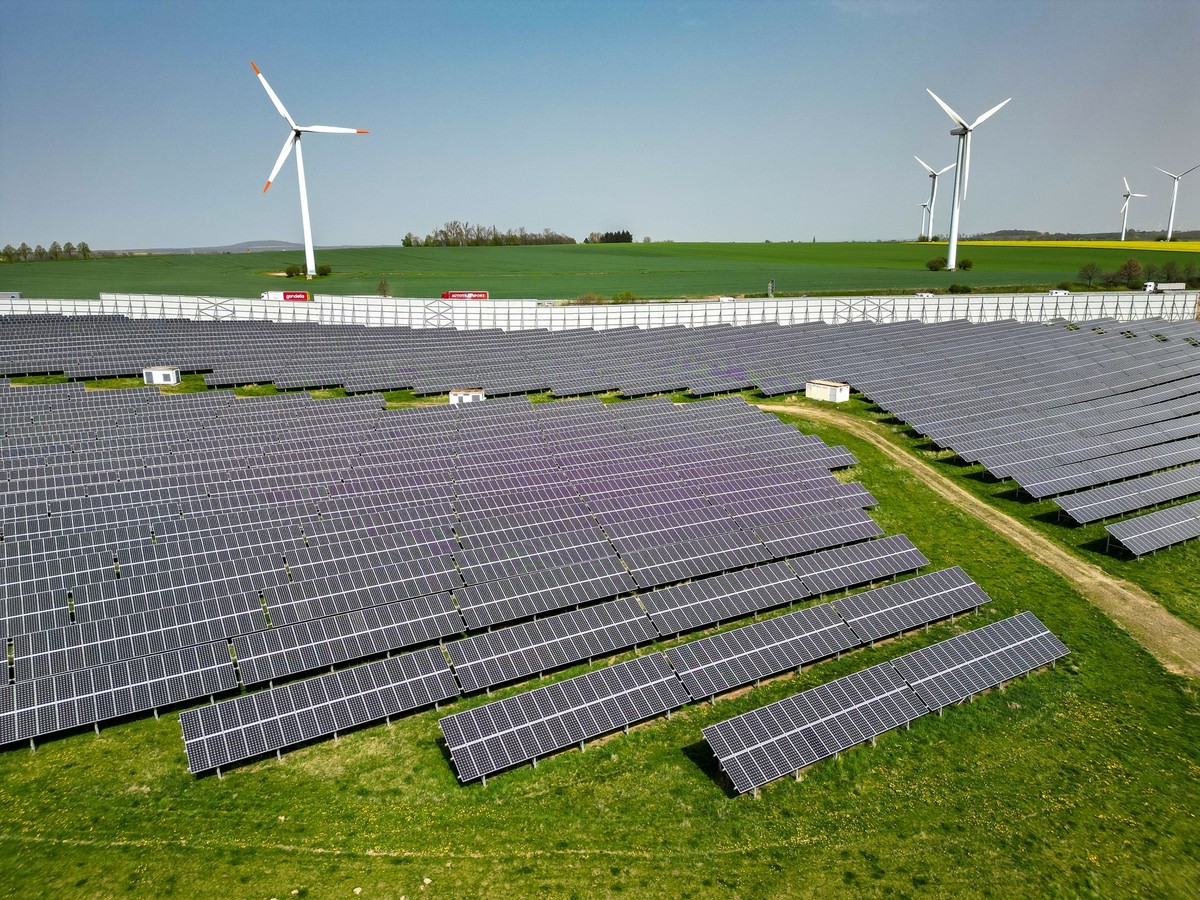 ARCHIV - 08.04.2024, Sachsen, Leisnig: Mehrere Windkraftanlagen stehen hinter einem Solarpark.(Luftaufnahme mit Drohne) (zu dpa: «EU-Kommission: Nicht nur Preis beachten bei Auktionen für Erneuerbare» ...