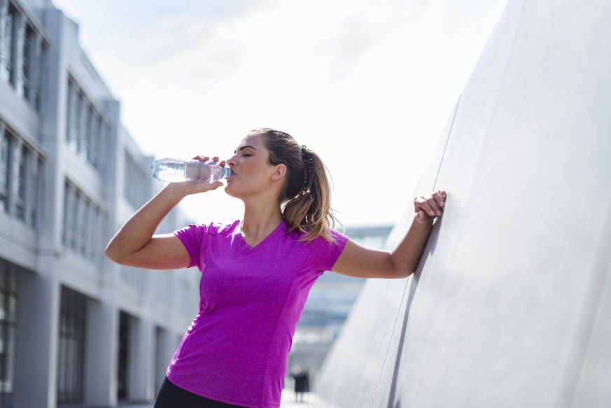 Young woman having a break from exercising drinking from bottle model released Symbolfoto PUBLICATIONxINxGERxSUIxAUTxHUNxONLY DIGF04052