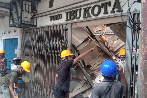 21.11.2022, Indonesien, Cianjur: Arbeiter inspizieren ein bei einem Erdbeben beschädigtes Geschäft. Ein Erdbeben der Stärke 5,6 erschütterte am Montag die westliche Provinz Westjava in Indonesien. Fot ...