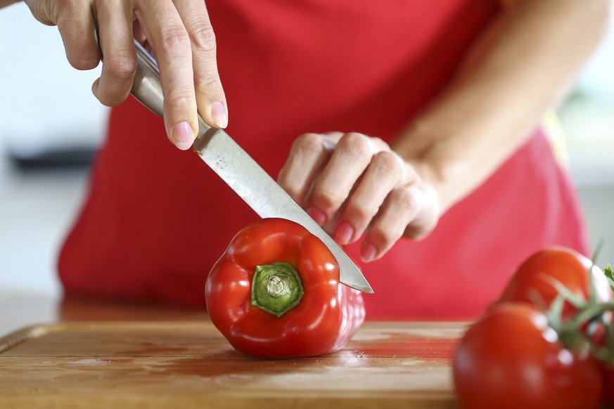 Woman cuts vegetables in the kitchen