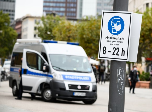 26.10.2020, Hessen, Frankfurt/Main: Ein Einsatzfahrzeug der Stadtpolizei steht auf der Zeil hinter einem Schild mit dem Hinweis auf die Maskenpflicht. Die Bankenstadt hat aktuell eine Versch�rfung der ...