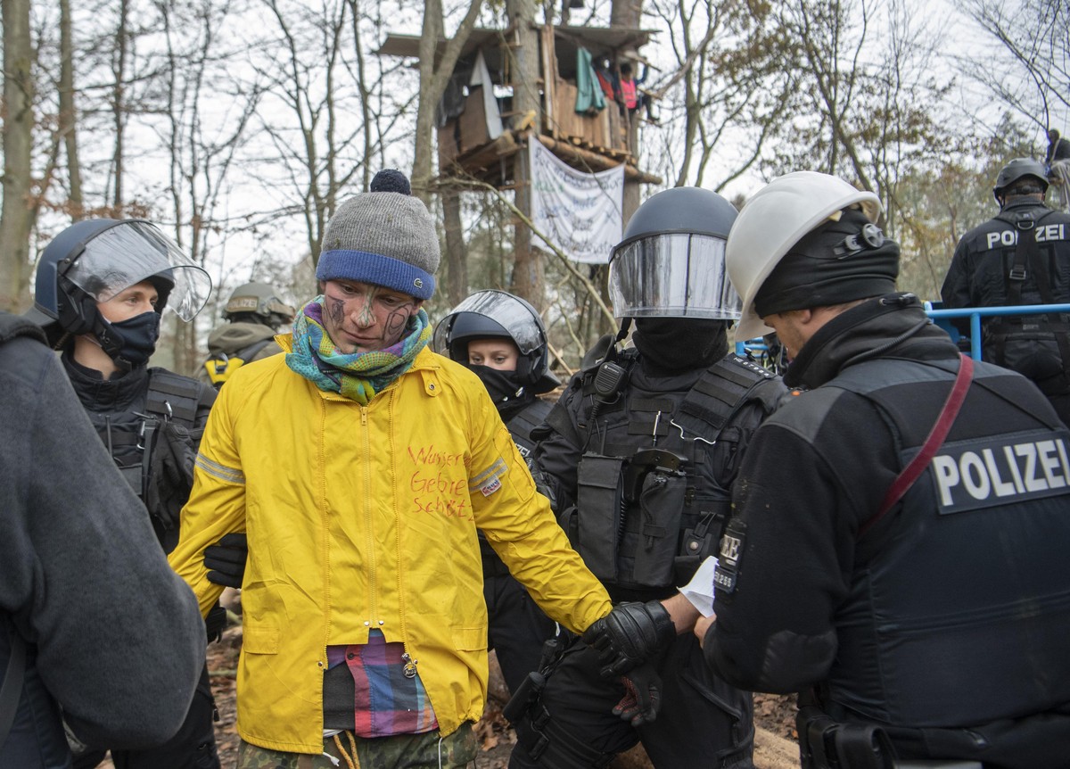10.11.2020, Hessen, Niederklein: Ein Aktivist (gelbe Jacke), der sich in einem Baumhaus verschanzt hatte, wird von Polizisten festgenommen. Derzeit halten Aktivisten den Dannenröder Forst besetzt und ...