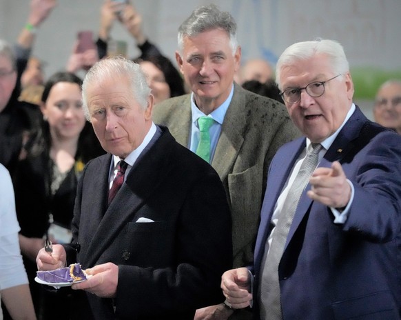 30.03.2023, Brandenburg, Brodowin: König Charles III. von Großbritannien (l) hat ein Stück Torte, die speziell für seinen Besuch angefertigt wurde, auf dem Biohof Brodowin im Dorf Brodowin, etwa 80 Ki ...