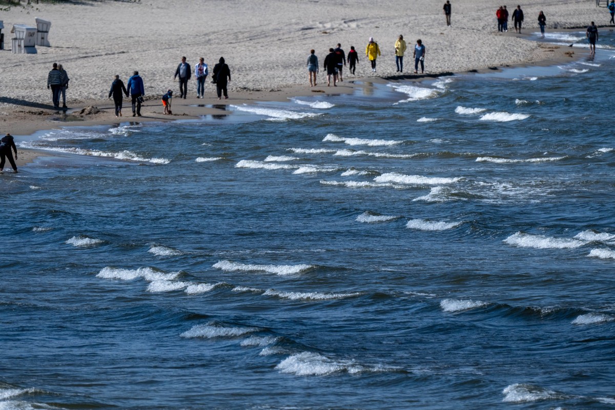 03.05.2025, Mecklenburg-Vorpommern, Heringsdorf: Spaziergänger sind bei sonnigem Wetter am Strand auf der Insel Usedom unterwegs. Foto: Stefan Sauer/dpa +++ dpa-Bildfunk +++