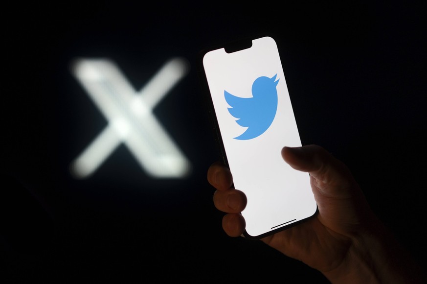 Elon Musk Changes Twitter Bird Logo To X A Twitter logo is seen on a mobile device with the X logo in the background in this photo illustration on 23 July, 2023 in Warsaw, Poland. Warsaw Poland PUBLIC ...