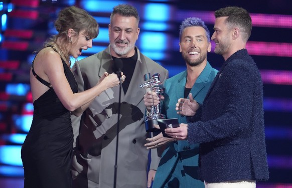 Joey Fatone, from center, Lance Bass, and Justin Timberlake of NSYNC present the award for best pop to Taylor Swift, far left, for &quot;Anti-Hero&quot; during the MTV Video Music Awards on Tuesday, S ...