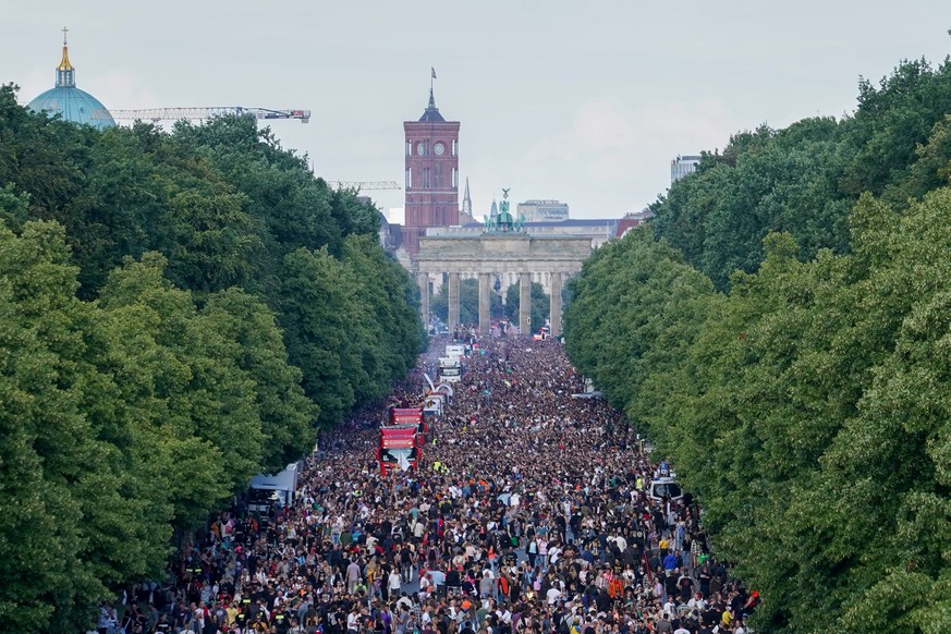 09.07.2022, Berlin: Unter dem Motto &quot;Rave the Planet&quot; zieht eine Parade aus Technofans tanzend am Brandenburger Tor vorbei. Rave the Planet, ein Nachfolger der Loveparade, versteht sich als  ...