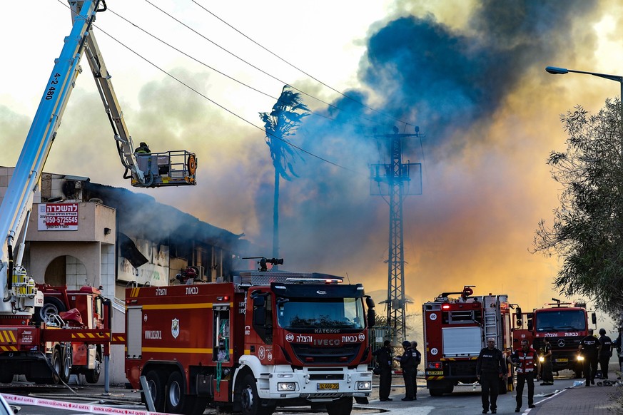 (191112) -- SDEROT, Nov. 12, 2019 () -- Israeli firefighters put out fire at a burning factory hit by rockets fired from the Gaza Strip in the southern Israeli town of Sderot, Nov. 12, 2019. Some 50 r ...