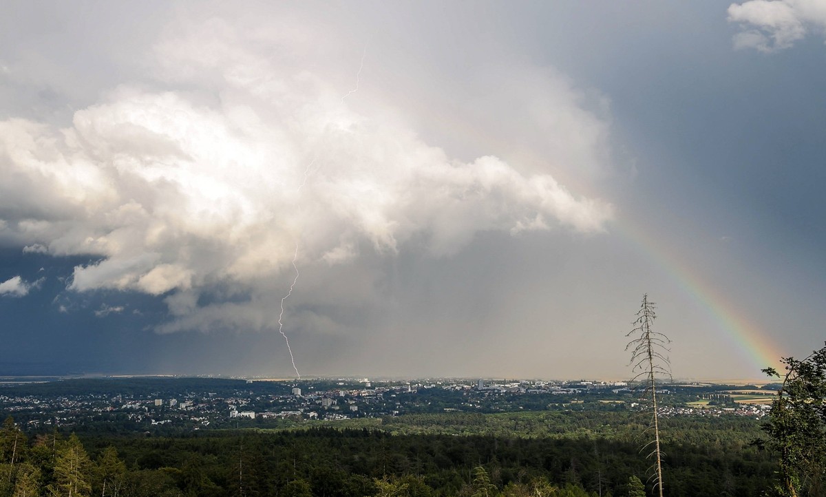 Blitz und Regenbogen Der Blitz eines Gewitters schl