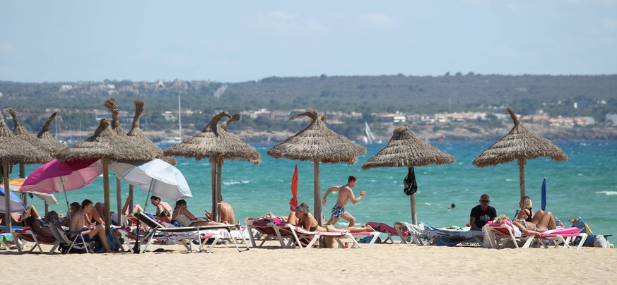 Urlauber liegen unter Sonnenschirmen an der Playa de Palma. Platja de Palma Mallorca *** Holidaymakers lie under umbrellas at Playa de Palma Platja de Palma Mallorca