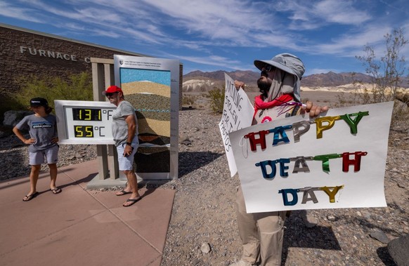 FURNACE CREEK, CALIFORNIA - JULY 16: Activist Tom Comitta demonstrates at the unofficial thermometer at the Furnace Creek Visitor Center indicating a temperature of 131 degrees Fahrenheit, which is kn ...