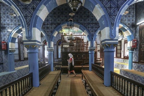 FILE - A tourist visits La Ghriba, the oldest synagogue in Africa, on the Island of Djerba, southern Tunisia, Oct. 28, 2015. The Tunisian Interior Ministry says a naval guard shot and killed a colleag ...