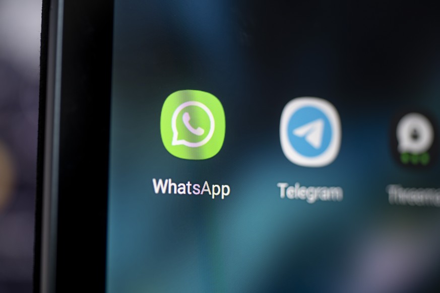 PRODUKTION - 28.04.2021, Berlin: Auf dem Bildschirm eines Smartphones sieht man das Logo der Messenger-App Whatsapp. WhatsApp geht gerichtlich gegen neue Regeln der indischen Regierung vor, die den Na ...