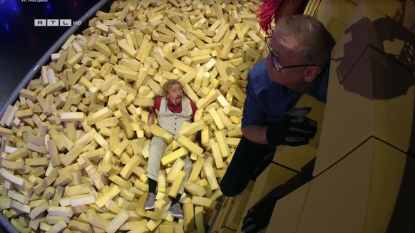 Thomas Gottschalk kann sich als erster nicht mehr an der Wand halten und fällt in die Polster.