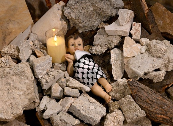 An installation of the baby Jesus laying in ruins, symbolizing children killed in Gaza, is seen in the Evangelical Lutheran Christmas Church in the biblical town of Bethlehem, West Bank, on Monday, De ...