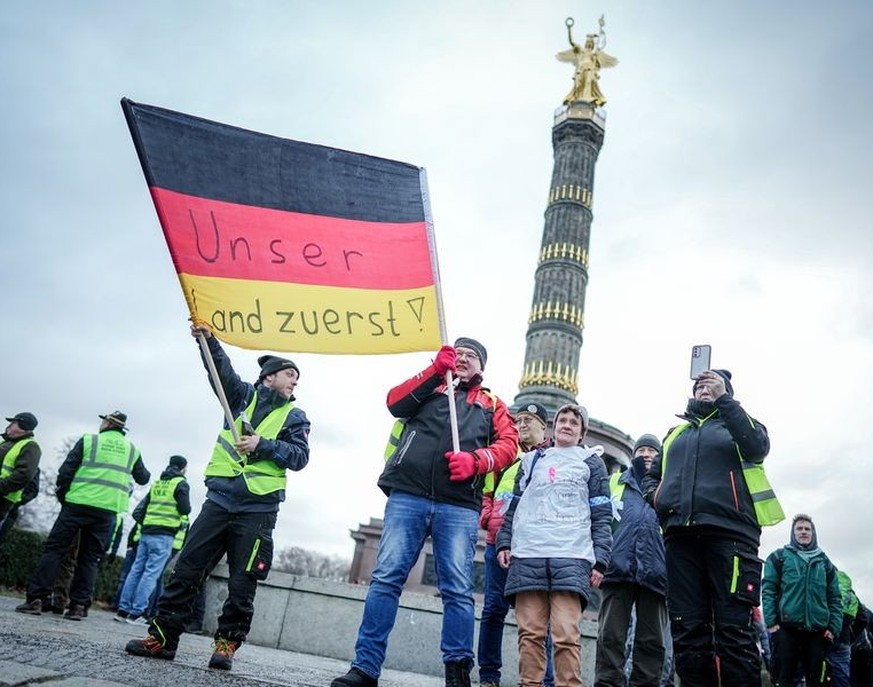 dpatopbilder - 15.01.2024, Berlin: Landwirte protestieren mit einer Deutschlandfahne mit der Aufschrift &quot;Unser Land zuerst&quot; vor der Siegessäule. Zum Abschluss der Aktionswoche der Landwirte  ...