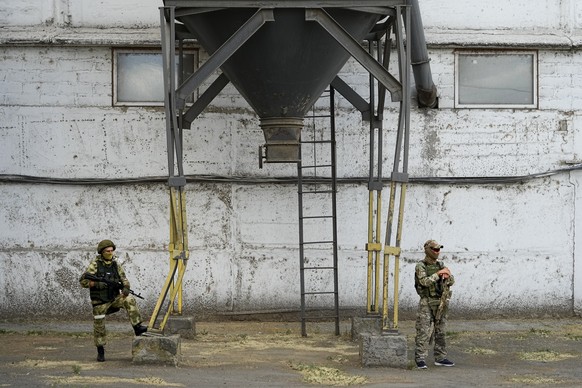 Russian soldiers guard an area as foreign journalists visit a grain elevator in Melitopol, south Ukraine, Thursday, July 14, 2022. About 300,000 tonnes of harvest have been collected in Melitopol dist ...