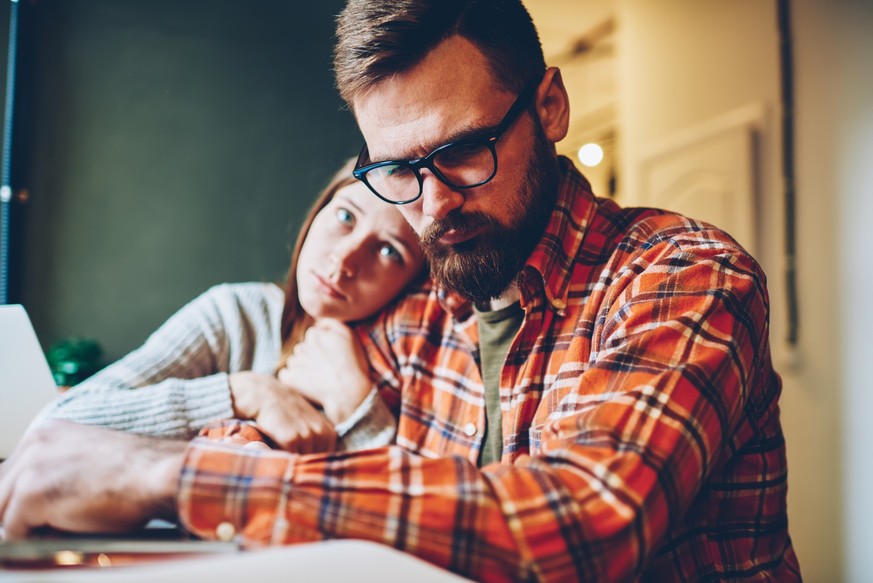 Loving young woman support her unmotivated boyfriend hugging and consoling during working difficulties.Compassionate hipster girl comforting desperate male designer after defeat sitting at home
