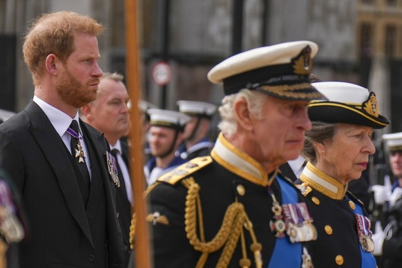 Prince Harry walks with Britain's King Charles III and Princes Anne behind the coffin of Queen Elizabeth II as it is pulled on a gun carriage through the streets of London following her funeral servic ...