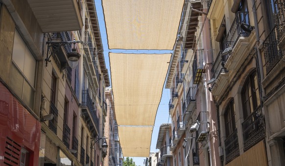 Fabric awnings between buildings to protect from the sun during hot summer days in the city of Granada, Spain