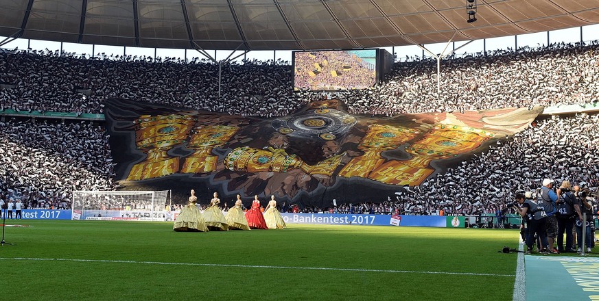 Auch im Vorjahr zog die Eintracht ins Finale ein. Auf einer großen Blockfahne ließen die Fans damals ihr Wappentier, den Adler, die bisherigen Trophäen präsentieren. Den fünften Pokal, den der Greifvogel hier in den Klauen hält, folgte erst 2018. 